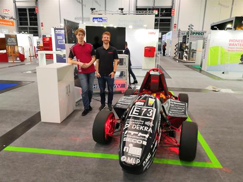 Henning Schäferhoff (li.) und Christian Braun vom Formula-Student-Team mit ihrem neuen Rennwagen bei der Messe Energy Storage. Foto: Daniel Schimkat